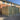 Green metal storage unit in front of a brick building